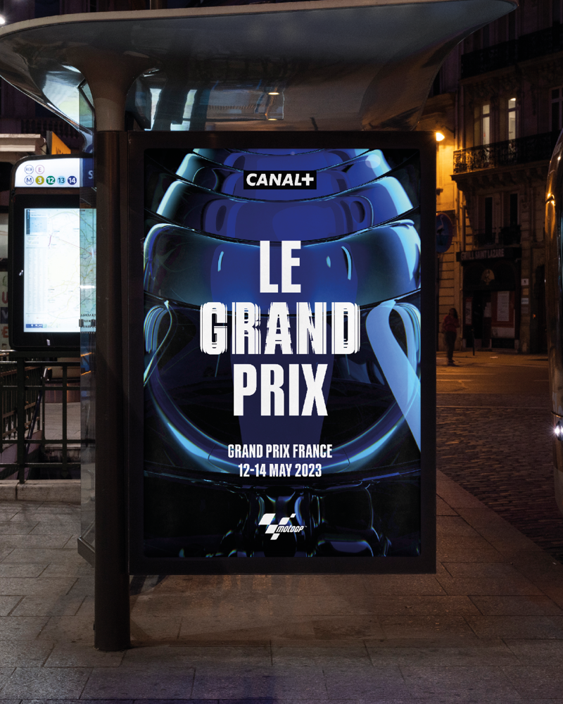 An out of home digital screen at a bus stop showing a Canal+ ad for Le Grand Prix